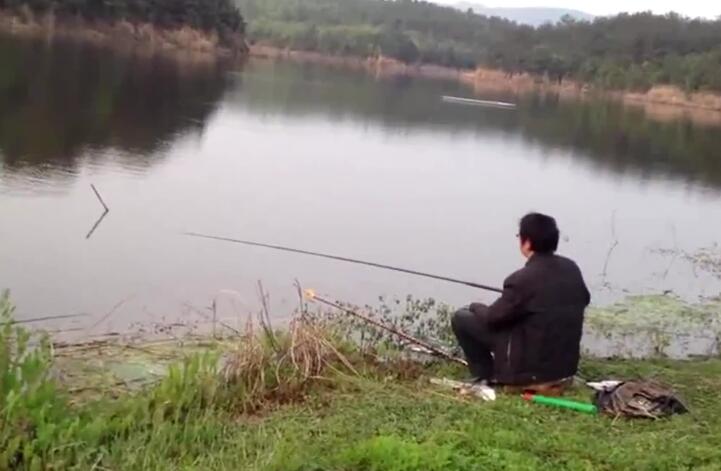 大姐全神貫注地在湖邊釣魚,收獲就是不一樣